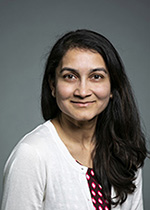 smriti in a white sweater in front of a professional photo backdrop
