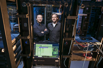 Professors Kai Zeng (left) and Jim Jones work together in the cyber-physical security lab. Photo by Ron Aira.